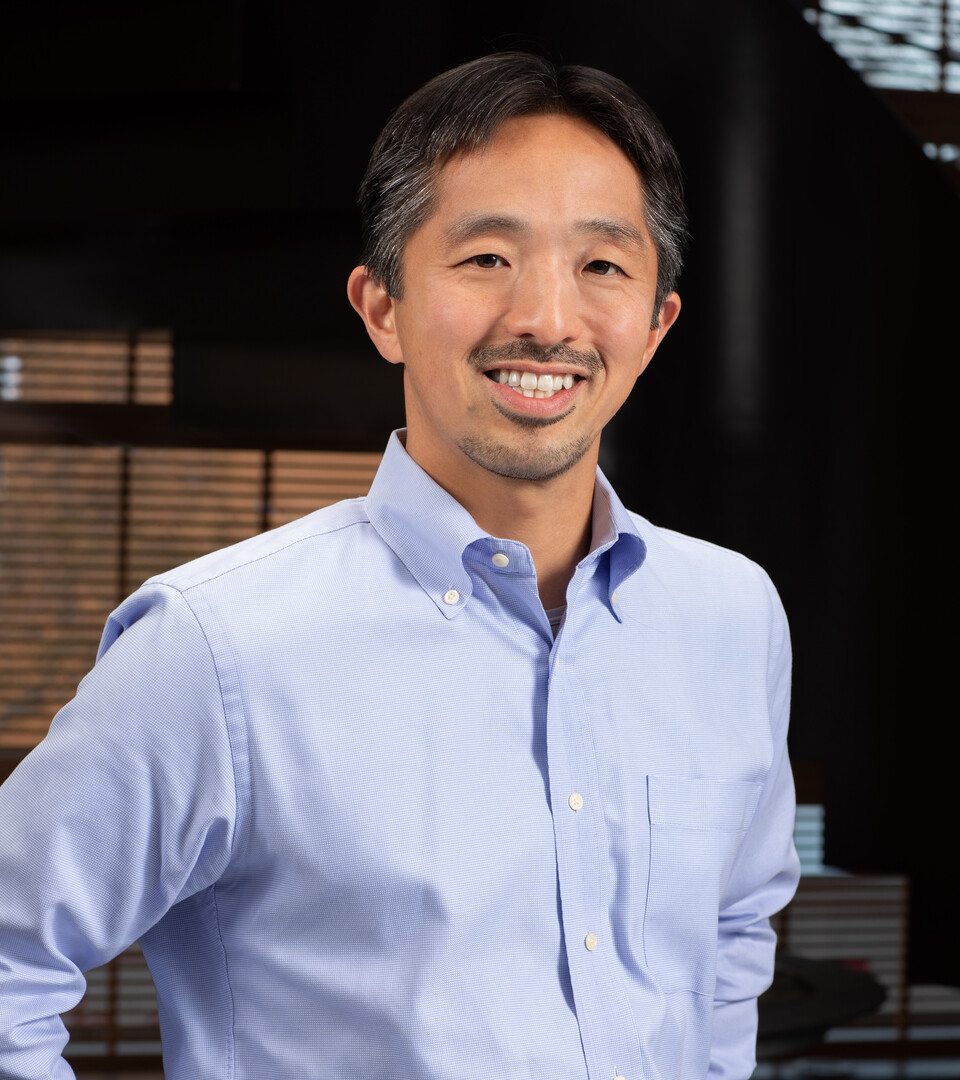 Porträt von Professor Imai mit hellem Hemd, er lächelt in die Kamera.